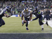 St. Louis Rams running back Benjamin Cunningham (36) is about to fumble in the end zone after a hit on the arm from Earl Thomas, left.