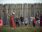 Eris Delay, 10, of Vancouver, plays with a ball while playing a villager for the 1840s during the Campfires and Candlelight event at Fort Vancouver National Historic Site in 2013. A new program, called Every Kid in a Park, encourages family visits to federally managed parks and attractions by giving fourth-graders a pass that allows family members to accompany them for free through Aug.