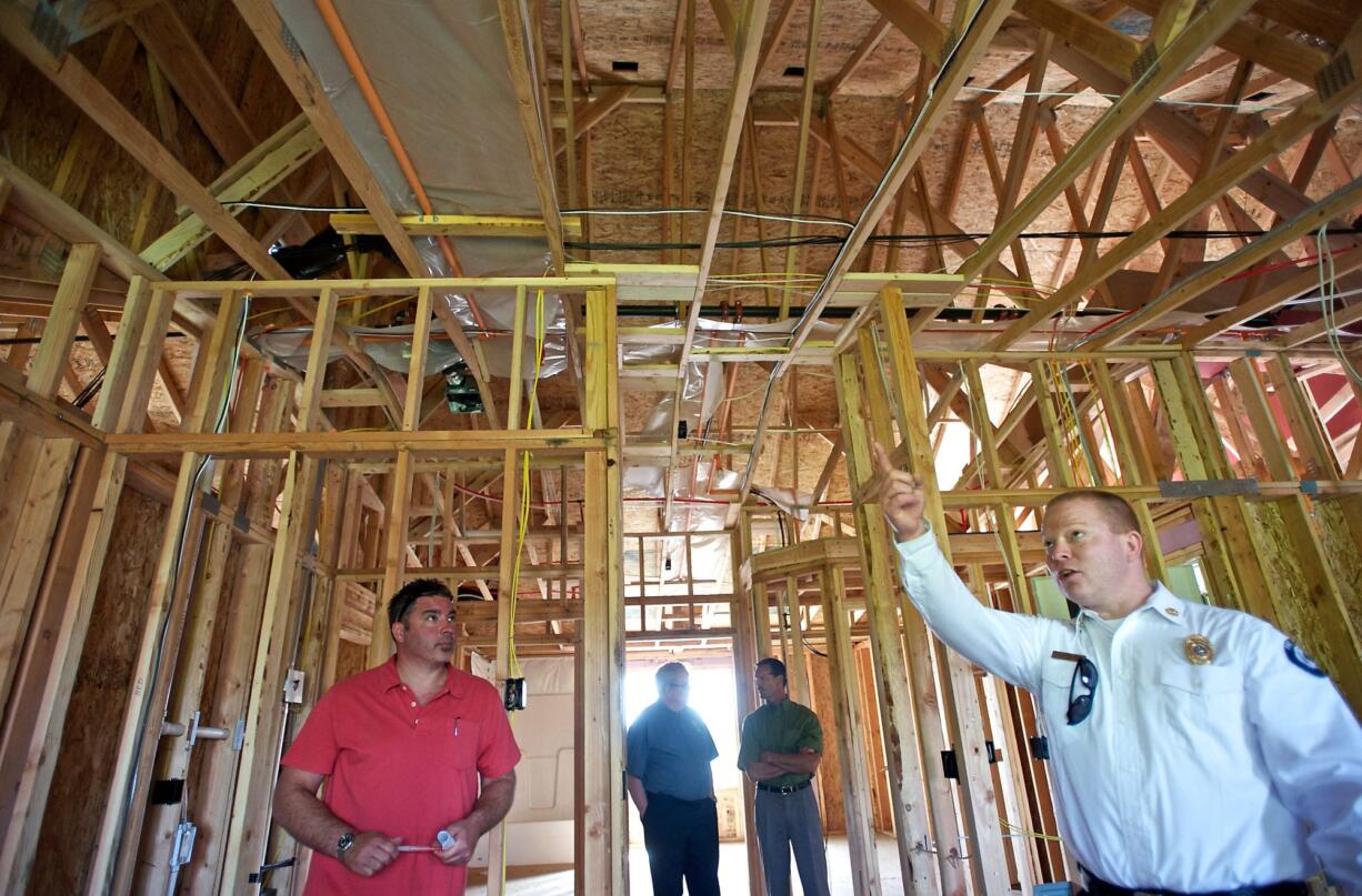 Clark County Fire District 6 Assistant Chief Shawn Newberry, right, points out modern fire safety features Thursday at the ArdenWood Station apartment complex in Hazel Dell.