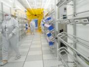 Linear Technology employees move through a corridor inside a clean room at the company's Camas manufacturing plant.