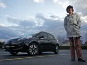 Jo Roberts poses for a portrait next to her Nissan Leaf on March 27 at Pacific Middle School in Vancouver.