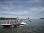 Oleg Babiy, 22, of Portland does a back flip off the back of a boat that was stopped on the Columbia River by the Clark County Sheriff's marine patrol boat for having out-of-state registration.