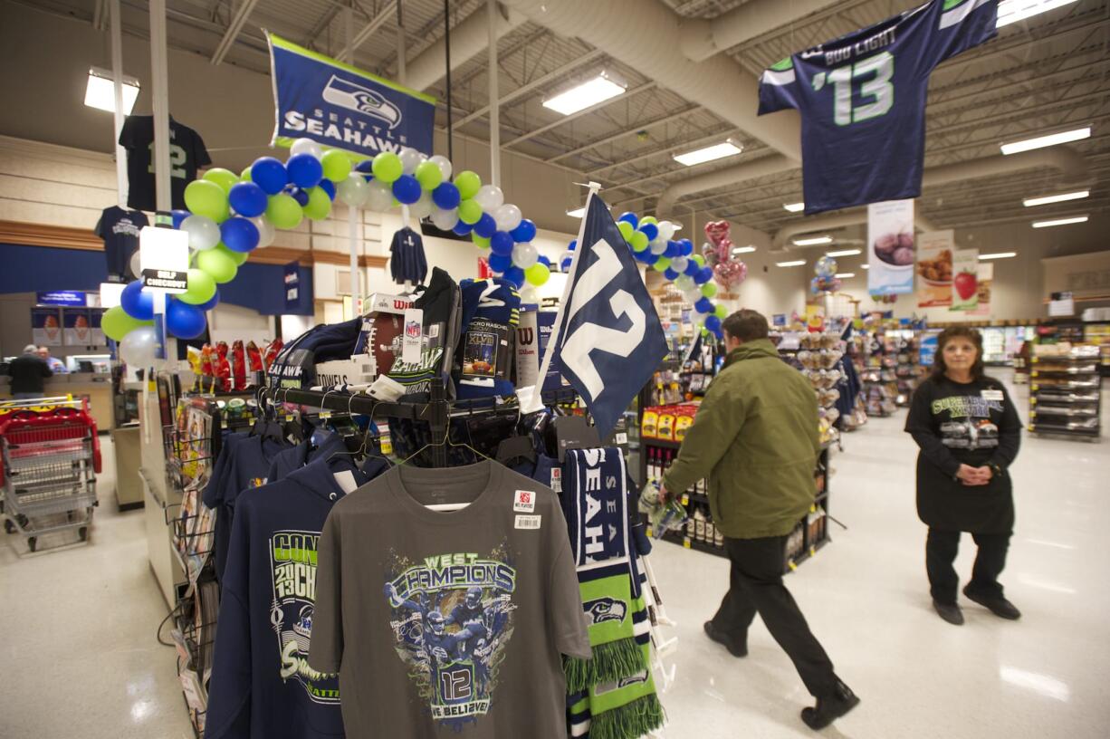 Shoppers pass a display of Seattle Seahawks gear at the Battle Ground Albertsons, which is selling everything from team-logo shirts and hats to Super Bowl party platters in preparation for Sunday's big game.