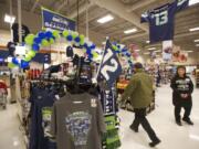 Shoppers pass a display of Seattle Seahawks gear at the Battle Ground Albertsons, which is selling everything from team-logo shirts and hats to Super Bowl party platters in preparation for Sunday's big game.