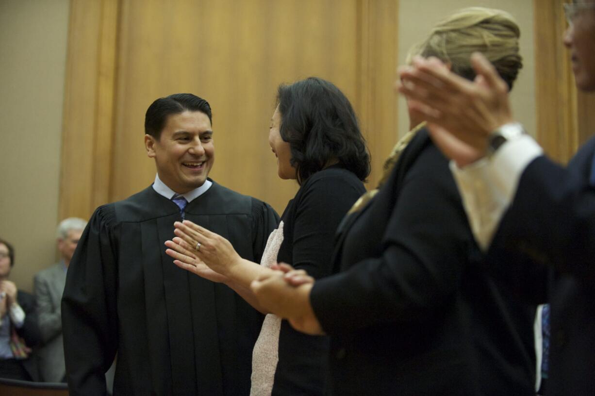 Bernard Veljacic looks at his wife, Pamela, after he is sworn in as Clark County's newest Superior Court judge Friday.