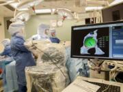 A 3-D image shows Dr. Todd Borus, an orthopedic surgeon with Rebound, where to use the MAKO surgical robot to remove bone and cartilage during a MAKOplasty hip replacement surgery Sept. 21 at Legacy Salmon Creek Medical Center. When Borus has removed enough bone and cartilage, the green area turns white. (Photos by Amanda Cowan/The Columbian)A 3-D image shows Dr. Todd Borus, an orthopedic surgeon with Rebound, where to use the MAKO surgical robot to remove bone and cartilage during a MAKOplasty hip replacement surgery Sept. 21 at Legacy Salmon Creek Medical Center. When Borus has removed enough bone and cartilage, the green area turns white.