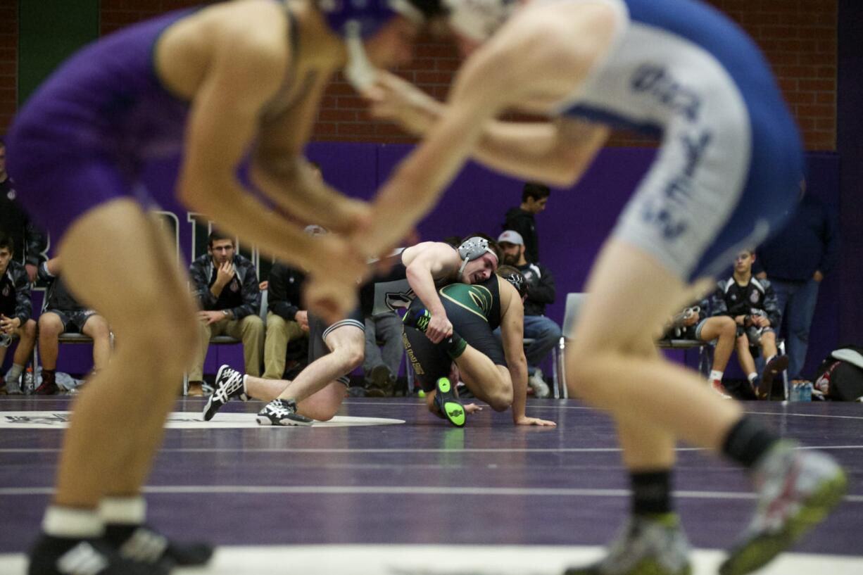 Union's Chase Wilson and Evergreen's Kristopher Walker, background, wrestle at 220 pounds as Heritage's Ebrahim Babajan and Skyview's Laycen Brown wrestle at 138 pounds in a pair of 4A GSHL dual matches at Heritage.