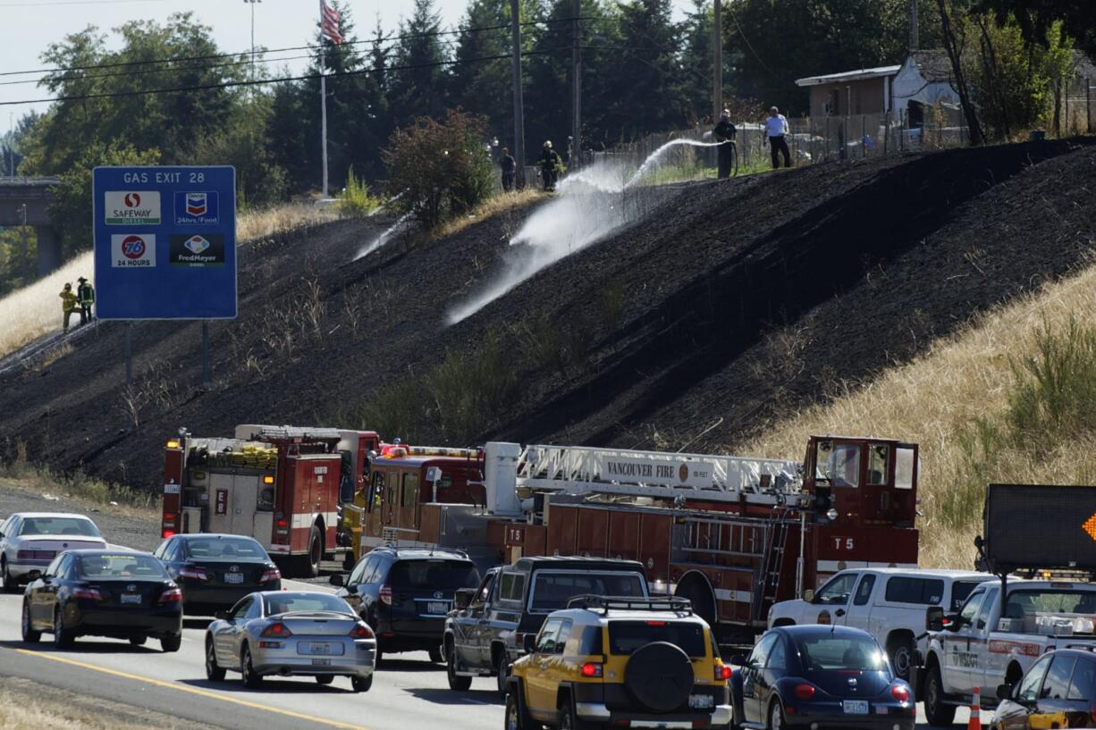 The right southbound lane of Interstate 205 was blocked Monday afternoon while firefighters put out a grass fire that investigators said likely was caused by a discarded cigarette.