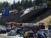 The right southbound lane of Interstate 205 was blocked Monday afternoon while firefighters put out a grass fire that investigators said likely was caused by a discarded cigarette.