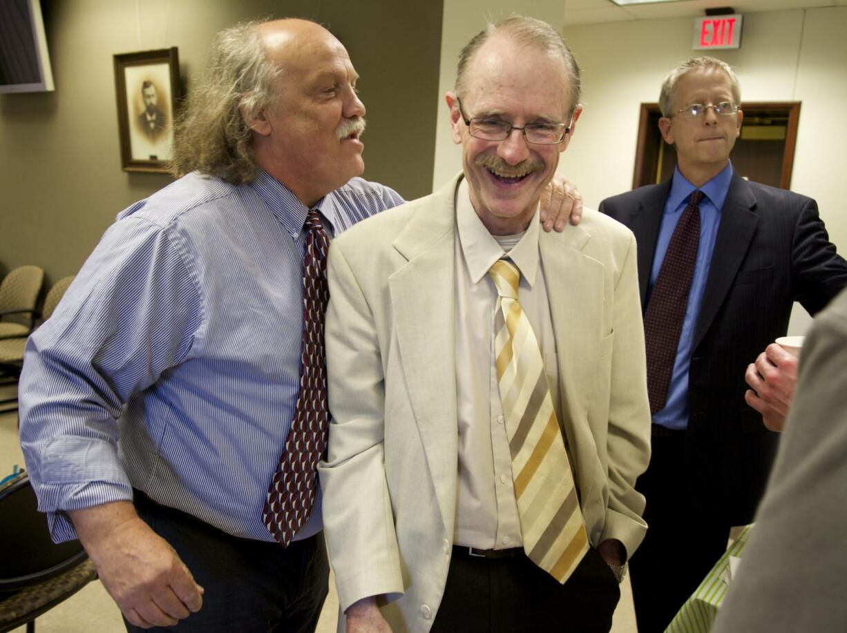 Defense attorney Gerry Wear, left, Friday greets pretrial release officer Kirk Pressey, center, at the Clark County Courthouse.