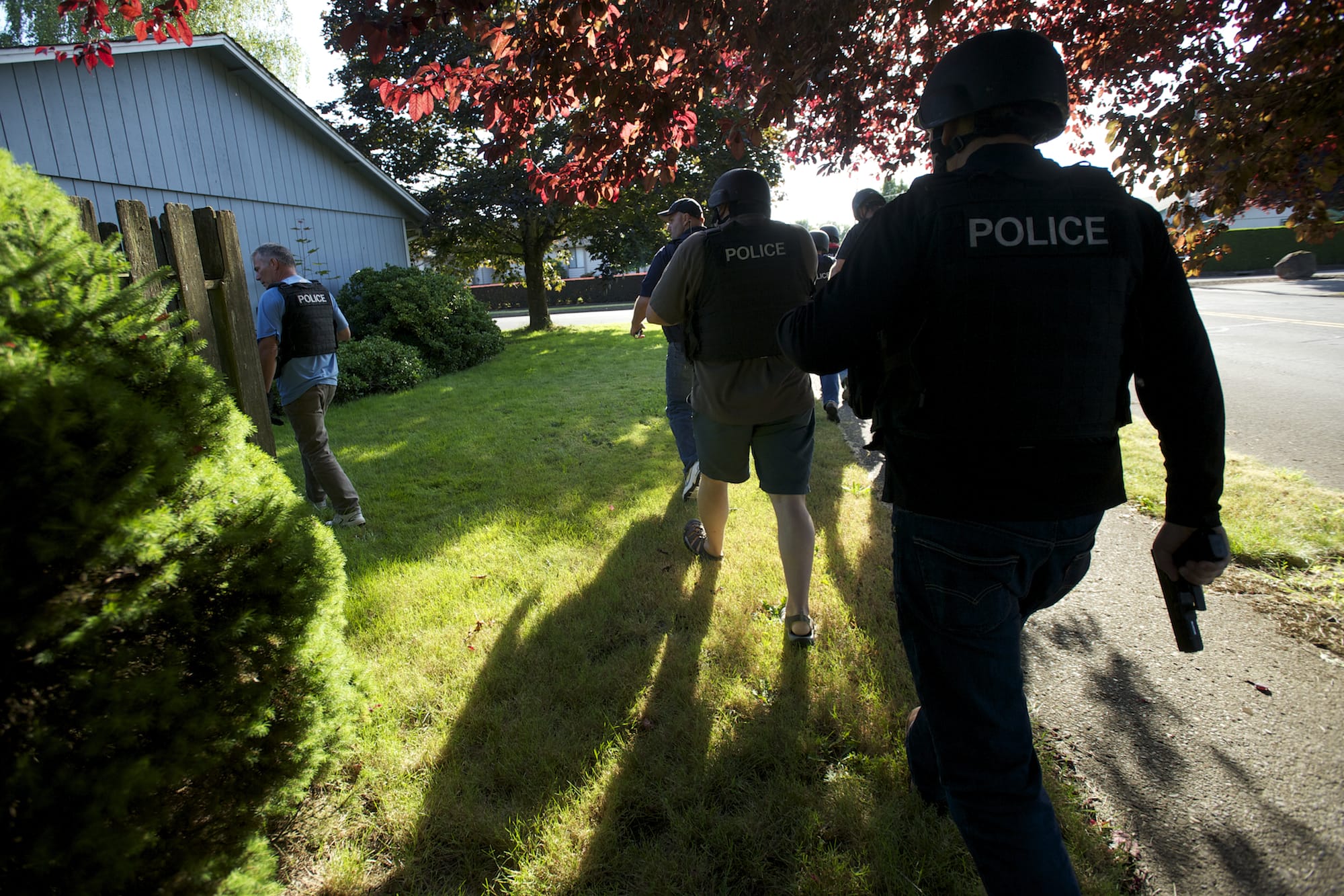 Undercover detectives with the Clark-Vancouver Regional Drug Task Force execute a search warrant at a suspected drug house in Felida on Wednesday.