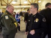 Vancouver Police Chief James McElvain talks with Clark County Sheriff Garry Lucas during a ceremony Thursday at the Water Resources Center in Vancouver.