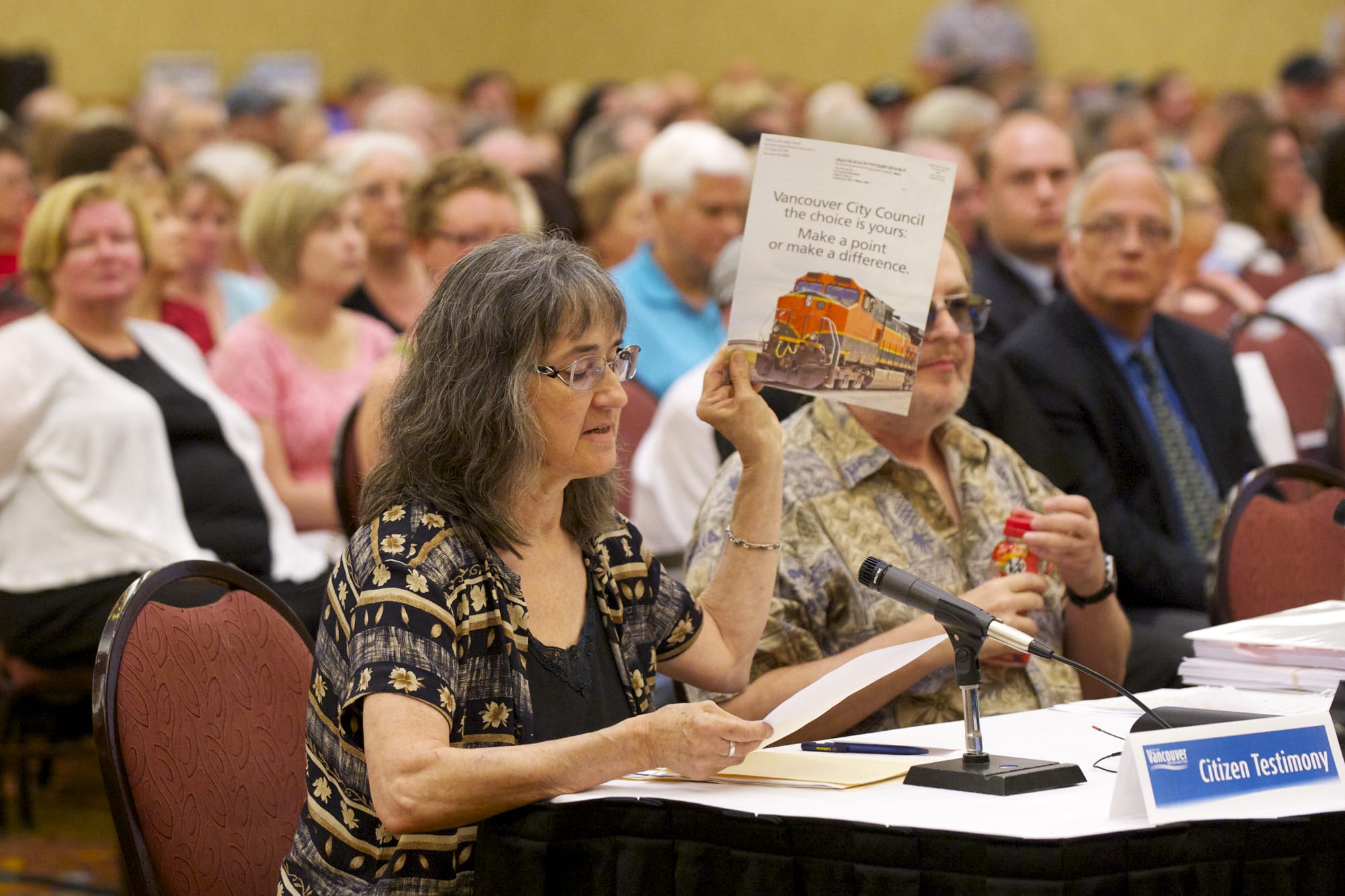 Vancouver resident Cathryn Chudy holds up a piece of mail she received from Tesoro-Savage as she testifies in front of the Vancouver City Council on Monday.