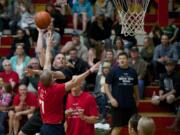 Steve Neal, from the Vancouver Police Department, puts up a hook shot over Vancouver Fire's John Larson in the first half of the Hoopin' with Heroes charity game Friday night at Fort Vancouver High School.