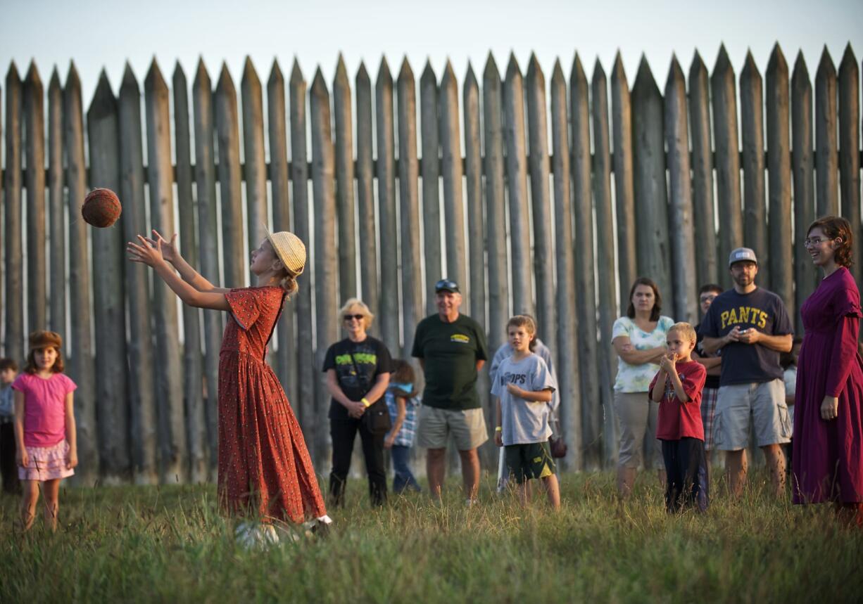 Eris Delay, 10, of Vancouver, plays with a ball while depicting a villager for the 1840's during the Campfires and Candlelight event at Fort Vancouver National Historic Site on Saturday September 14, 2013.