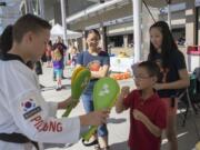 Nathan Chiu, 7, front center, learns about martial arts from Lanedon Wells, 13, of World Class Martial Arts while his sisters, Katie, back left, and Melodie watch at a health fair at Doc Harris Stadium on Saturday, Sept. 19, 2015.