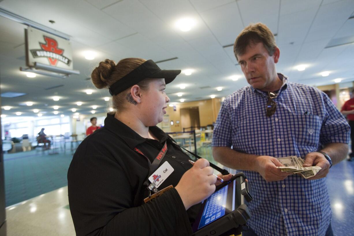 An employee takes an order at Burgerville's soft opening Saturday at the Portland International Airport.