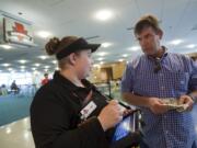 An employee takes an order at Burgerville's soft opening Saturday at the Portland International Airport.