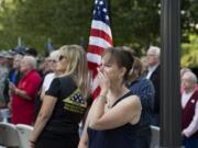 Christine Smith of Vancouver, center, and Mary Astrid of the Patriot Guard Riders, with flag, watch as doves are released in honor of the victims of Sept. 11, 2001 during a remembrance ceremony on Friday morning, Sept. 11, 2015 at Vancouver City Hall.