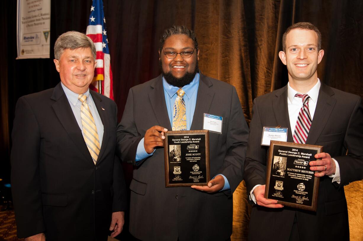 Rick Drake, from left, of the George C. Marshall Foundation, offers Vancouver High School senior Jose Scott the Marshall Youth Leadership Award and Matthew Bisturis the General George C.