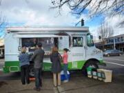 Customers visit the Mighty Bowl food truck in downtown Vancouver during the lunch rush Wednesday.