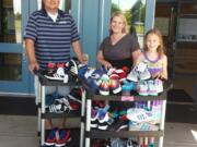 East Vancouver: Shahala Middle School Principal Gregg Brown, from left, staff member Katie Cowles and student Grace Brown with some of the 200-plus pairs of shoes the school&#039;s shoe drive brought in for Share.