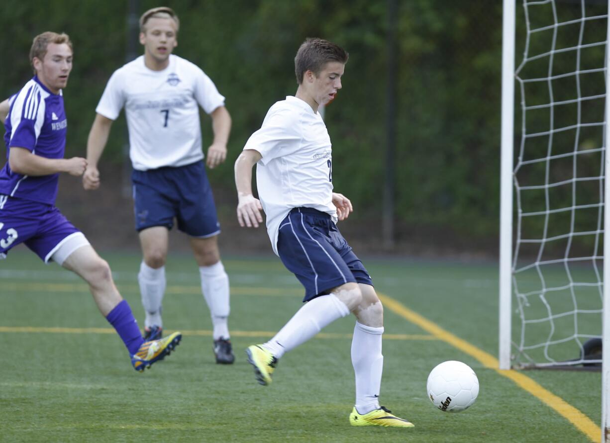 Skyview midfielder Gabriel Weber (R) chips in goal against Wenatchee in first round of class 4A state soccer playoffs at Kiggins Bowl.