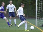 Skyview midfielder Gabriel Weber (R) chips in goal against Wenatchee in first round of class 4A state soccer playoffs at Kiggins Bowl.