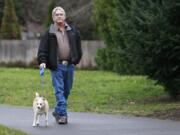 Ray Tabor walks his dog Toby near PeaceHealth Southwest Medical Center on Wednesday. Tabor spends more time walking Toby after an acute heart attack and a subsequent critical arrhythmia nearly killed him.