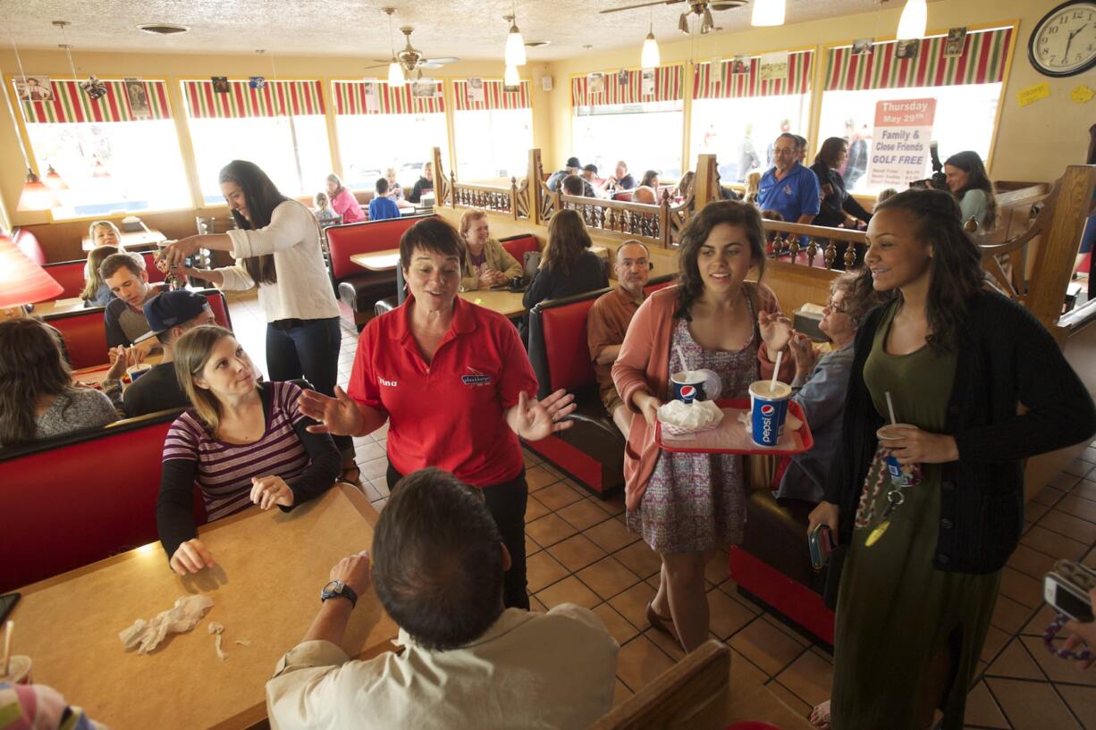 Tina Condon, who used to be a manager at Steakburger, talks with customers hours before the local restaurant closed for good Thursday.