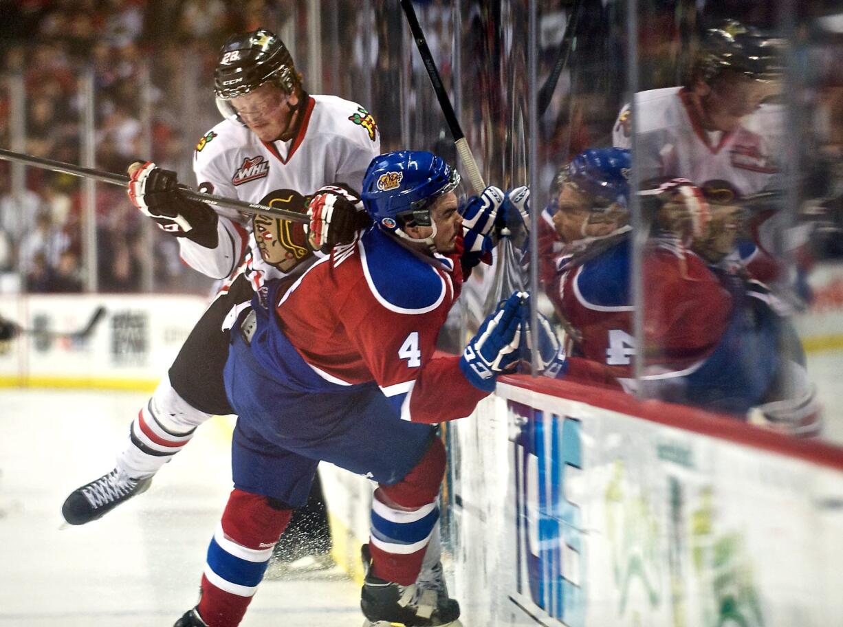 The Winterhawks' Alex Schoenborn check the Oil Kings' Blake Orban in the second period of game 5 of the WHL finals at the Moda Center on Friday May 9, 2014.