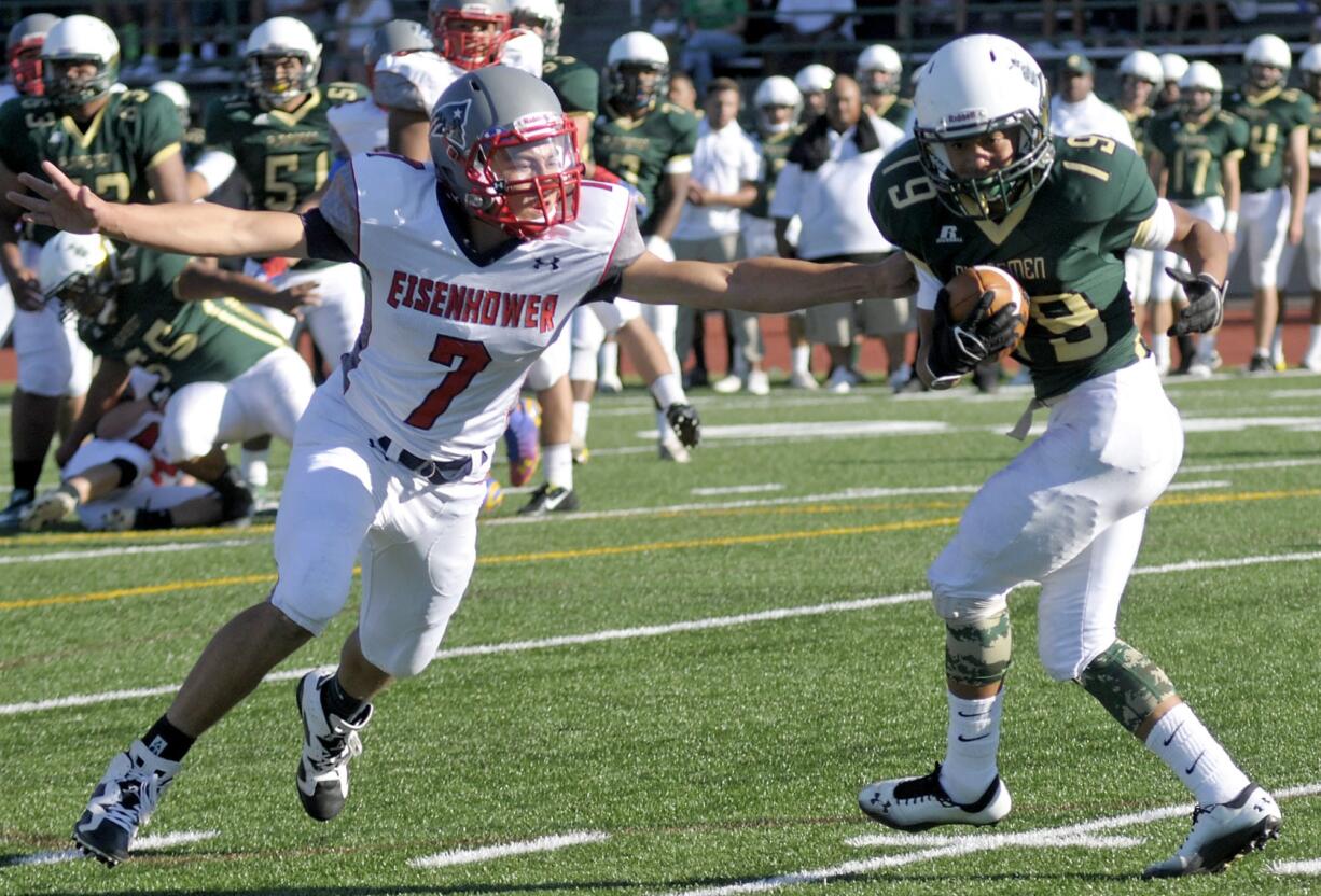 Evergreen's Marquis Sampson, right, pushes past Eisenhower's Noah Ramirez in the first half on Friday night at McKenzie Stadium.