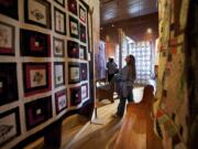 Sewer and crafter Deborah Schmitz of La Center looks up Sunday at a quilt on display at the North Clark Historical Museum in Amboy.