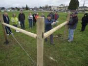 Trevor Prothero, center right, of Wilco farm supply uses a level to check a post while leading a fence-building class last month at the ninth annual Small Acreage Expo at 78th Street Heritage Farm. New federal data show that while total acreage and farms were in decline in Clark County, the number of farms working 9 acres or less grew significantly.