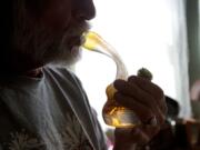 John, a 64-year-old chronic pain sufferer from Camas, smokes marijuana from a water pipe in his home Thursday.