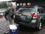 Vancouver City Councilor Larry Smith, who drives once a week for Meals on Wheels, loads his car at the Luepke Senior Center in Vancouver, Wa., Thursday., Dec 18, 2014.