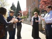 Ashley Myers of Portland, from left, Mitzy Timmins of Vancouver, Jessie Ghiglieri, a mental health outreach specialist with Americorps Vista; Brenda Huffstutler, a crime victim advocate with Lutheran Community Services Northwest; and Vancouver Mayor Tim Leavitt take part in a candlelight vigil Monday outside the Clark County Courthouse.