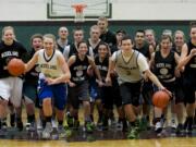 The Woodland boys and girls basketball teams, being led out by seniors Madison Sorensen and Tanner Huddleston (in light jerseys), are both one win from state in Yakima.