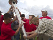 Connor Johnson, looking up at the pole, and a team of fellow Boy Scouts and adults put up a 30-foot flagpole Friday at the Harmony Sports Complex in Vancouver. Johnson organized the effort as his Eagle project to honor Capt. Christopher Stover, a U.S.