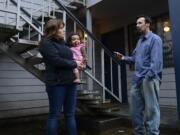 Natalia Mosley, holding onto daughter Isabel, chats with neighbor Kevin Giard about the upheaval at Courtyard Village Apartments, where new owners have begun notifying residents that they'll need to leave because of pending renovations and rises in rent.