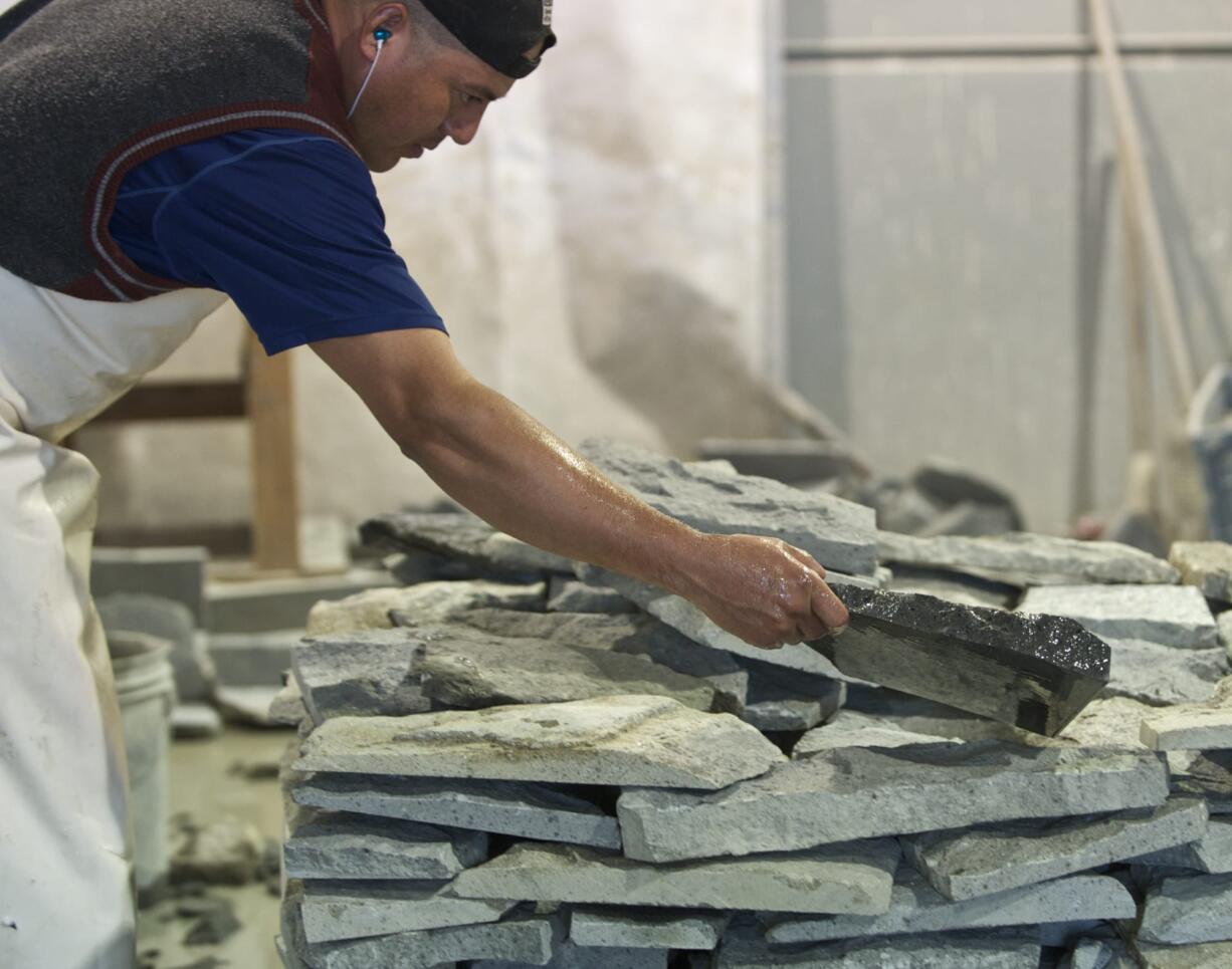 Zachary Kaufman/The Columbian
Leo Galbez places a cut stone on a stack of stones that will be used as veneers at DeCorado Stone