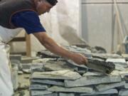 Zachary Kaufman/The Columbian
Leo Galbez places a cut stone on a stack of stones that will be used as veneers at DeCorado Stone