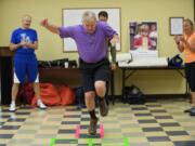 Vancouver City Councilmember Larry Smith competes in a game of Celebrity Hopscotch at the Share Fromhold Service Center as part of the Give More 24 charity event, Thursday, September 18, 2014.