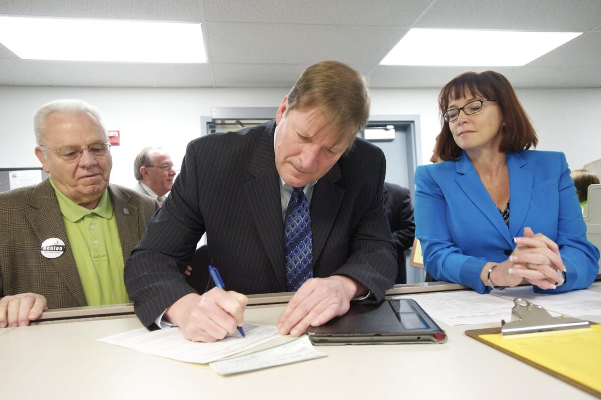 Flanked by Democrats Ed Barnes and Kelly Love Parker, Craig Pridemore files for county commissioner at the Clark County Elections Office this morning.