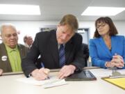 Flanked by Democrats Ed Barnes and Kelly Love Parker, Craig Pridemore files for county commissioner at the Clark County Elections Office this morning.