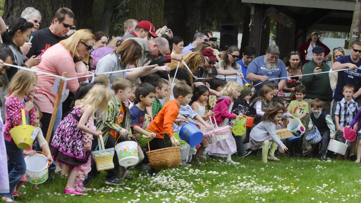 Children race onto the field as an Easter egg hunt begins Sunday at Crown Park in Camas.