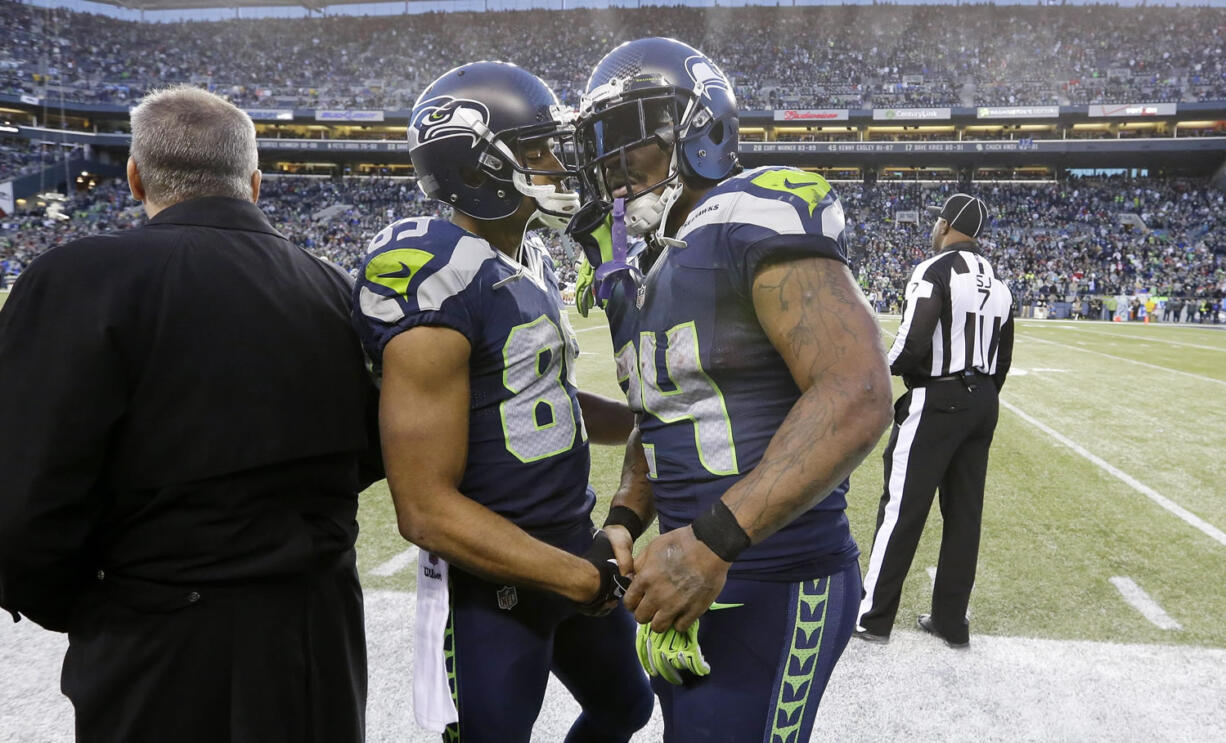 Seattle Seahawks' Doug Baldwin, center left, shakes hands as Marshawn Lynch heads off the field against the San Francisco 49ers late in the second half Sunday in Seattle.