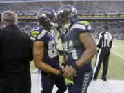 Seattle Seahawks' Doug Baldwin, center left, shakes hands as Marshawn Lynch heads off the field against the San Francisco 49ers late in the second half Sunday in Seattle.