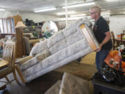 Employee Billy Peck arranges furniture for sale at Xchange Thrift Store in Vancouver.