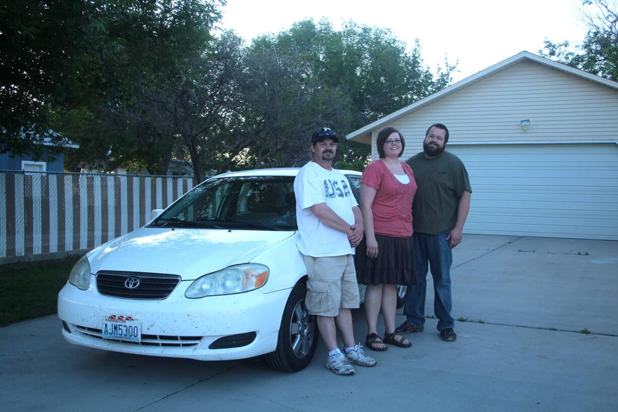 Randy Misner, from left, Leslie Holmes and Rob Holmes of Price, Utah, stand next to Rowan Coash's car.